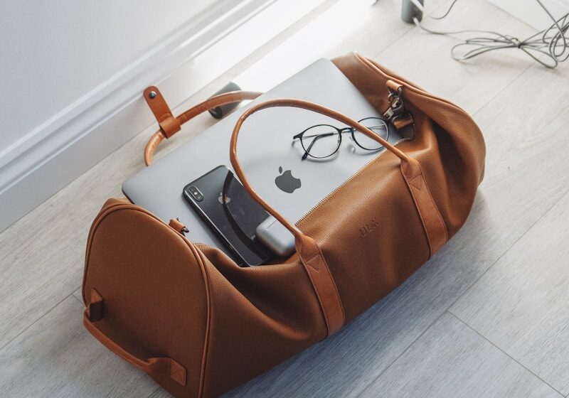 silver MacBook in duffel bag